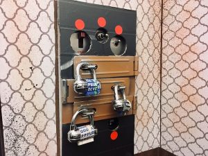 In-game: an elevator control panel covered in hasps and locked up.