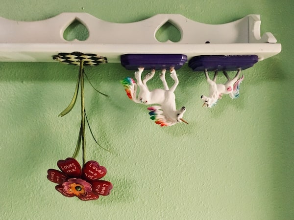 In-game: An upside down shelf with a pair of unicorns and a flower.