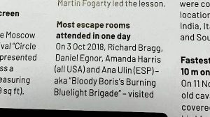 Part one of the print entry reads: "Most escape rooms attended in one day. On 3 Oct 2018, Richard Bragg, Daniel Egnor, Amanda Harris (all USA) and Ana Ulin (ESP) - aka "Bloody Boris's Burning Bluelight Brigade" - visited"