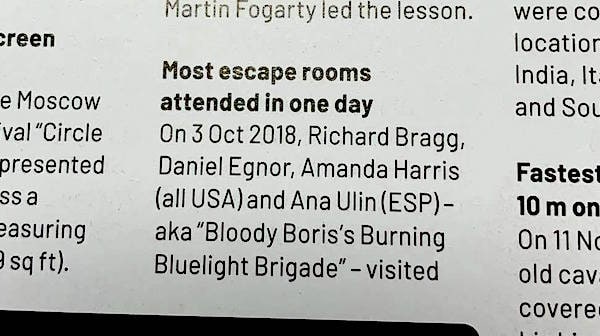 Part one of the print entry reads: "Most escape rooms attended in one day. On 3 Oct 2018, Richard Bragg, Daniel Egnor, Amanda Harris (all USA) and Ana Ulin (ESP) - aka "Bloody Boris's Burning Bluelight Brigade" - visited"