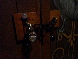 In-game: closeup of a doorway chained with a padlock.