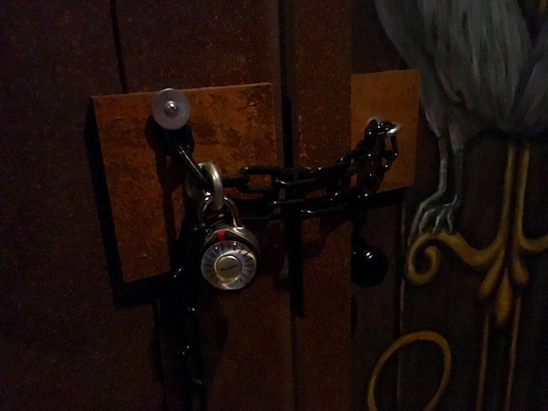 In-game: closeup of a doorway chained with a padlock.
