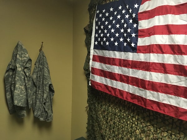 In-game: A pair of camo jackets beside an american flag.
