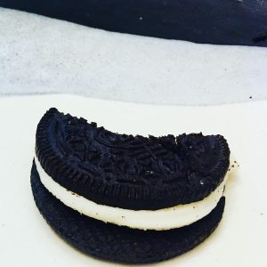 Closeup of a half eaten oreo on a plate.