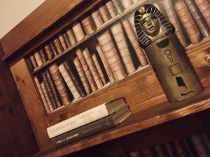 In-game: A bookshelf with a sarcophagus statue.