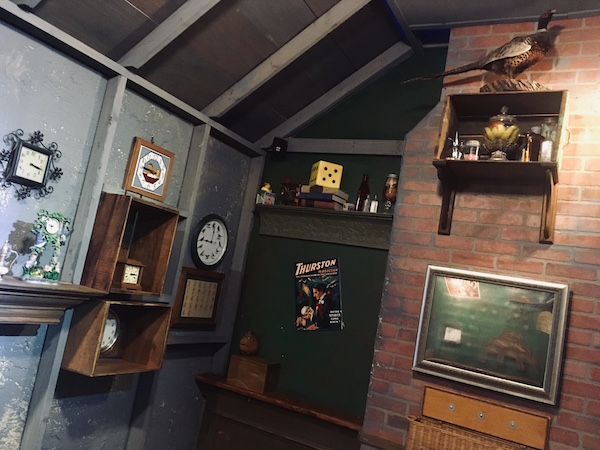 In-game: wide view the Kazam's study, clocks, and other items hang on the walls.
