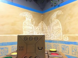 In-game: A large cube resting atop a pyramid in inside of bright ruins.