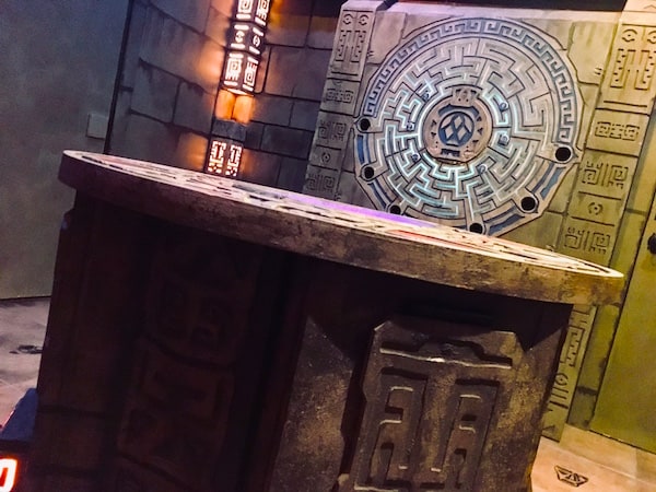 In-game: a stone alter before a large maze.