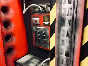 In-game: closeup of containment technology, there are buttons and knobs.