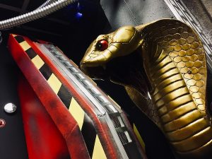 In-game: Closeup of a king cobra statue surrounded by technology.