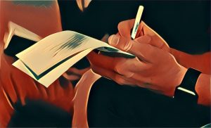 Hands writing a note on a notepad.