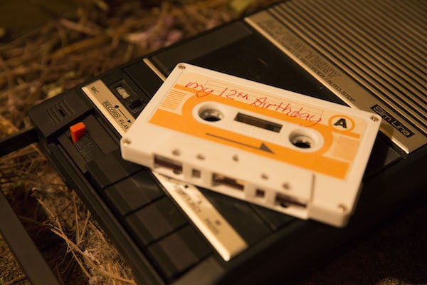 A cassette tape labeled "My 12th Birthday" sits on top of a tape recorder.