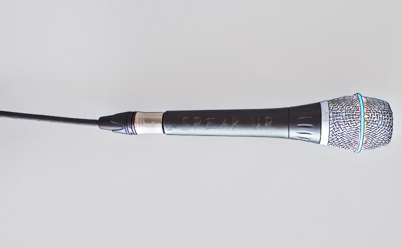 A microphone with the words "Speak Up" scratched into it.