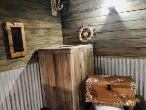 In-game: Inside of a fishing boat, there are crates, and chests.