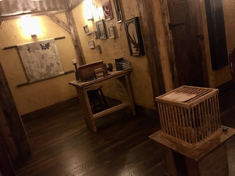 In-game: Wide view of the Quest's set, a wizard's study.