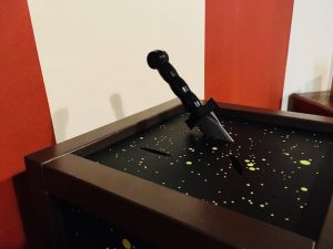 In-game: A magical prop, a box with constellations painted on it, slits cut in it, and a knife embedded in one of the slits.