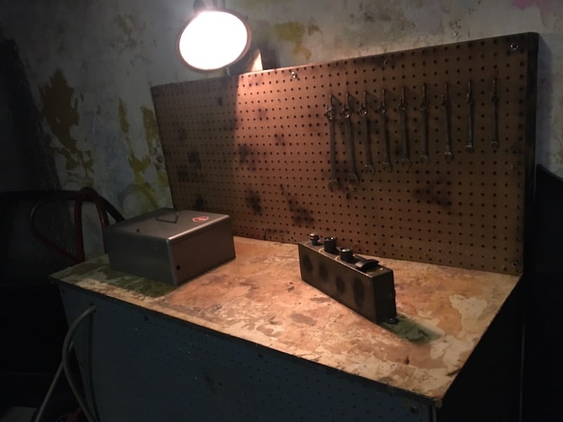 In-game: a workbench with wrenches hanging from a pegboard.