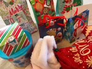 An assortment of bagged and wrapped christmas gifts.