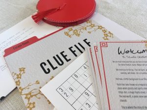 A welcome letter, part of a sudoku, a folder for clues, a collapsed lantern, and part of a script.