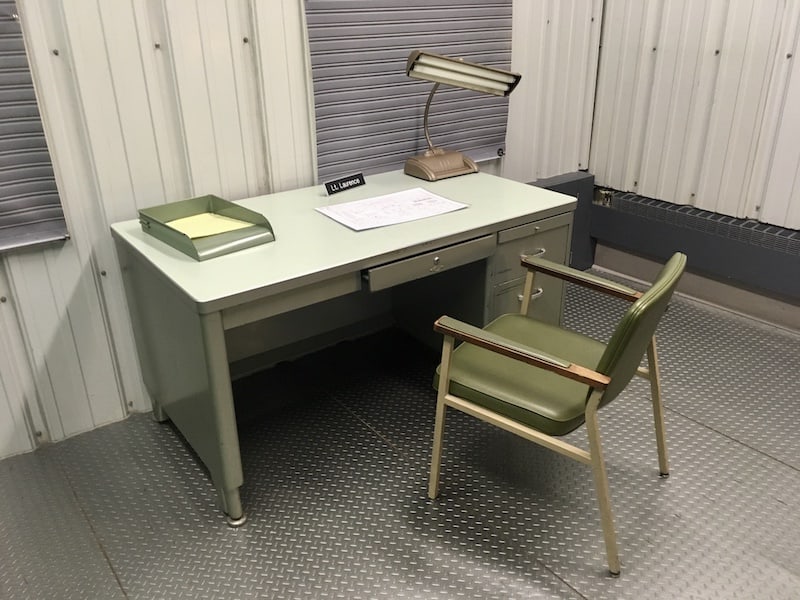 In-game: A metal desk in the middle of an old nuclear bunker.