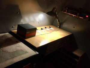 In-game: a large wooden workbench with a light.