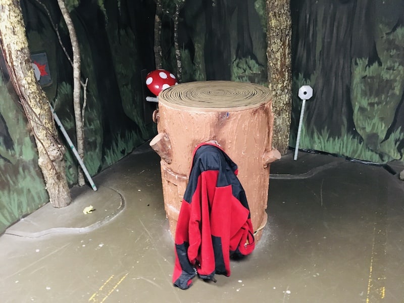 In-game: A stump with a a fleece hung on it in the middle of the woods.