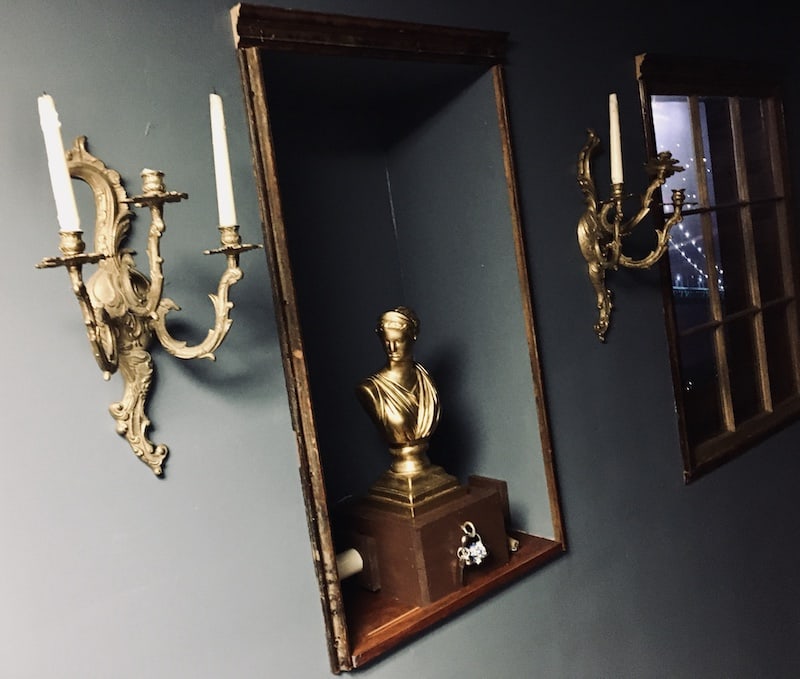 In-game: Astatue in the wall of a hallway within a hotel.