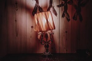 In-game: closeup of a tilted lamp in a grim room.