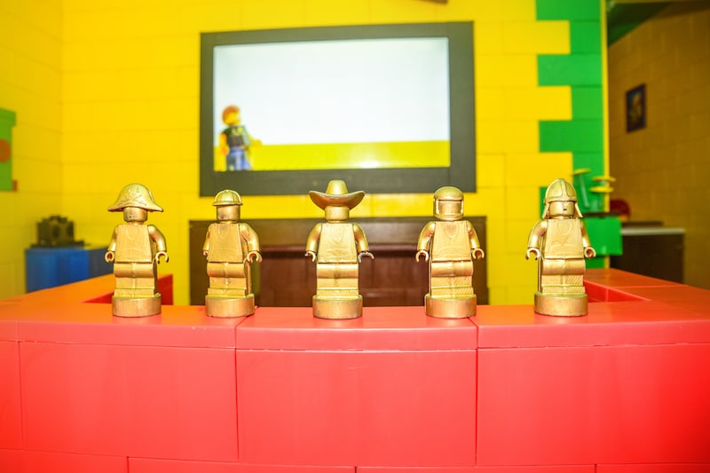 In-game: A lego chair in front of a TV in a lego house.