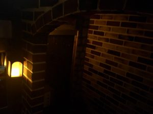 In-game: A brick building at night lit by lantern.