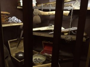 In-game: View through the window of an armory storefront.