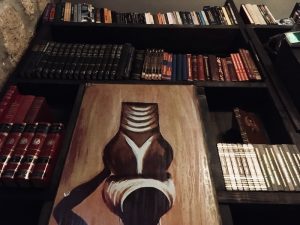 In-game: A tall bookshelf decorated in African art.