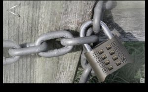 A number padlock binding a heavy chain around a wooden gate.