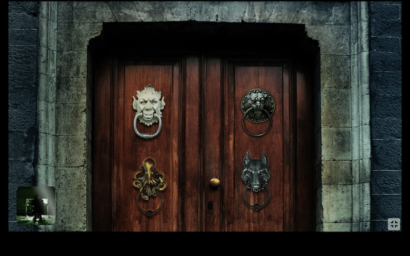 A door with 4 different knockers on it. A demon, a lion, a wolf, and an octopus.