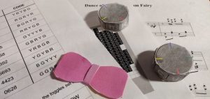 A collections of papers, cipher dials, and a pink paper bowtie.