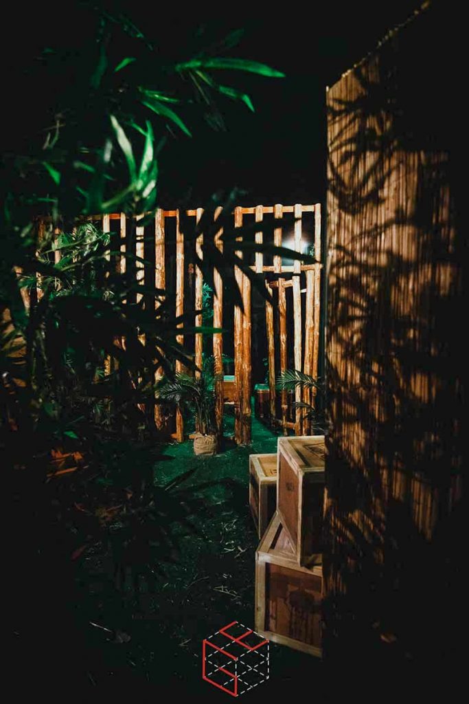 In-game: A grassy area filled with wood crates and walls structures.