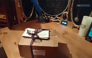 A sealed box on a table surrounded by magical props.
