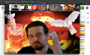 Nick Moran with a doctored German flag behind him, including a baby with a unicorn horn, milk & honey, a dove, a nuclear explosion, and Aynd Rand.