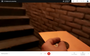 A hand holding a wax sealed envelope as the holder approaches a stairwell.