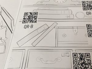 A black & white printed page depicting a bookcase labeled with QR codes.