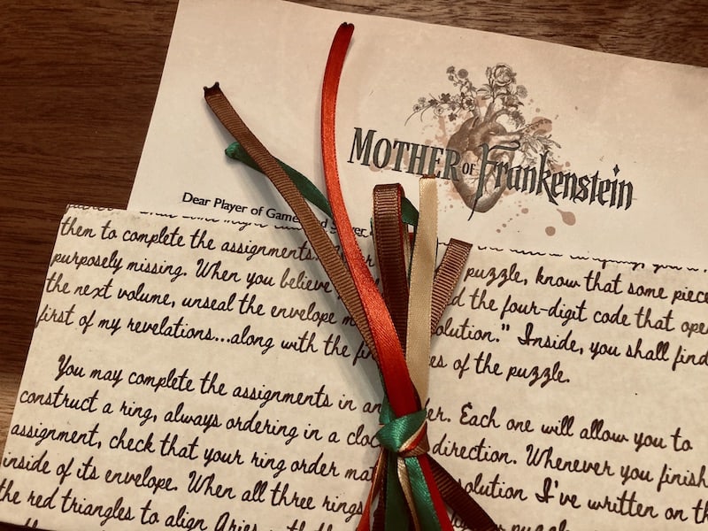A welcome letter tied off with red, green, and brown ribbon.