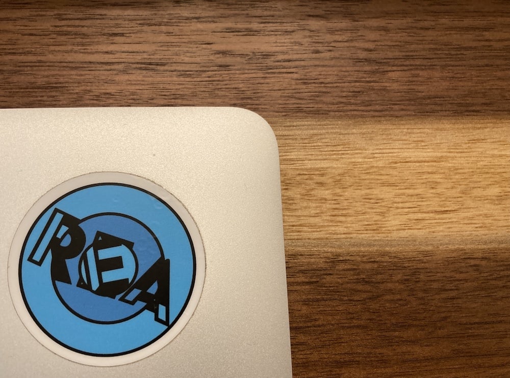 REA sticker on a laptop. 
