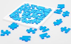 29 translucent blue acrylic jigsaw pieces and a white frame that fits them.