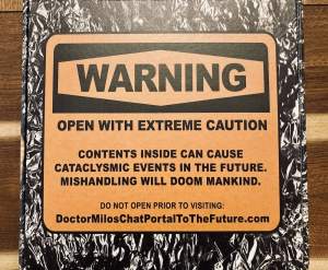 A foil-covered box with an orange warning that reads: "Open with extreme caution. Contents insid can cause cataclysmic events in the future. Mishandlign will doom mankind."