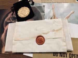 A wax sealed letter and a gold coin.