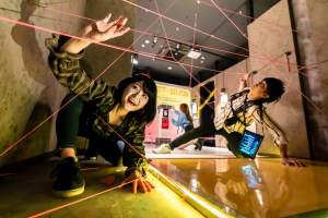 Players navigating a laser maze made of string.