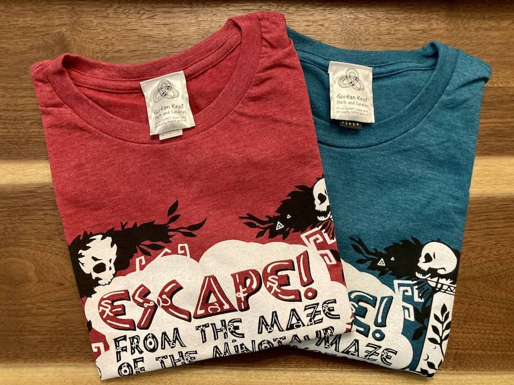 Red and teal puzzle shirts folded and laying beside one another.