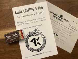 An open matchbox, a rune casting primer, and a nordic post telegram.