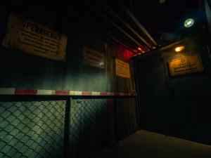 dark room with german signs on the wall and chain link fencing