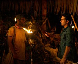 two men standing in front of a torch about to be snuffed from the reality tv show survivor